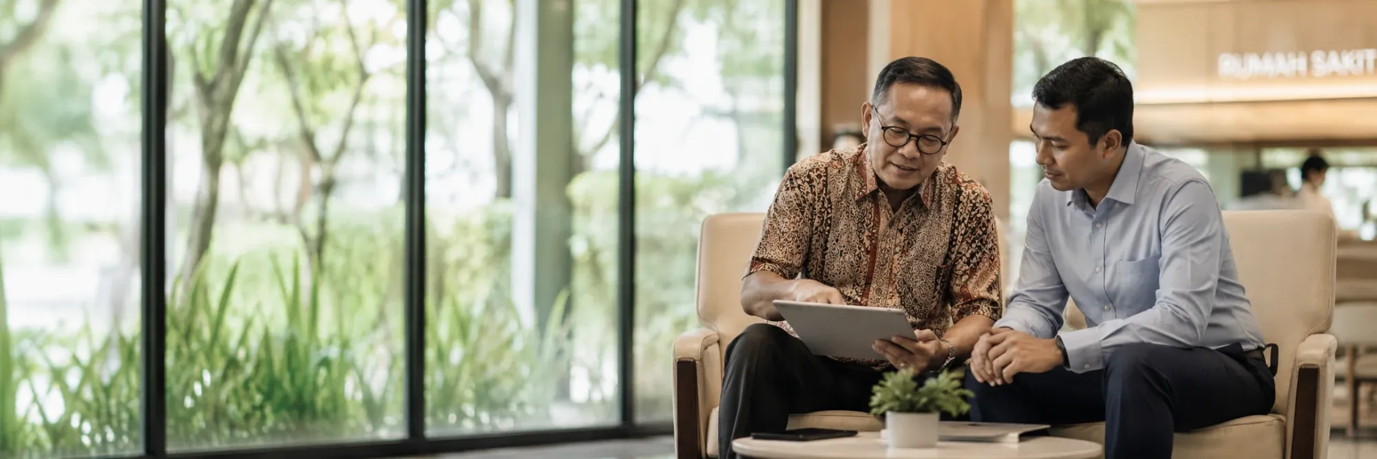 An advisor reviewing cover with a client in the lobby of a network hospital