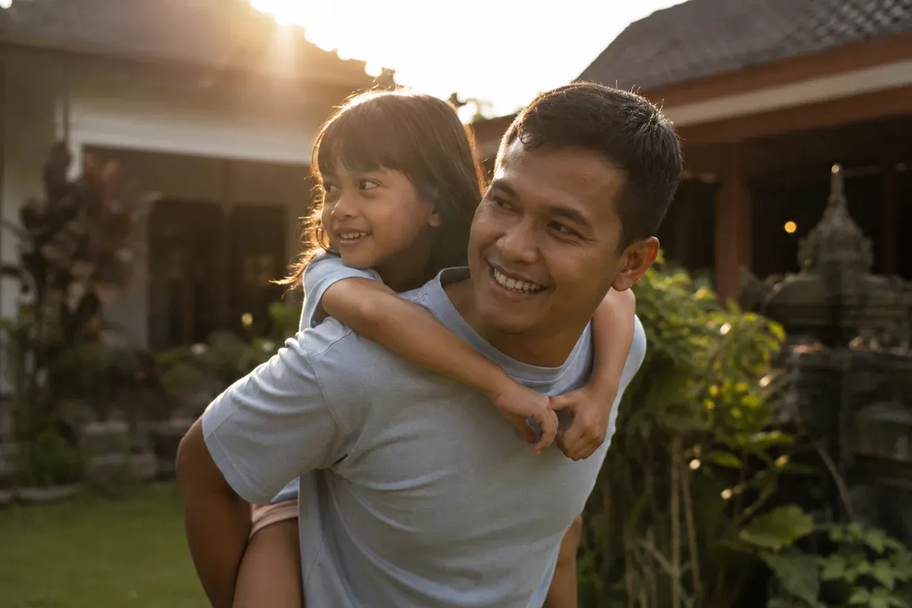 Father carrying his daughter at golden hour